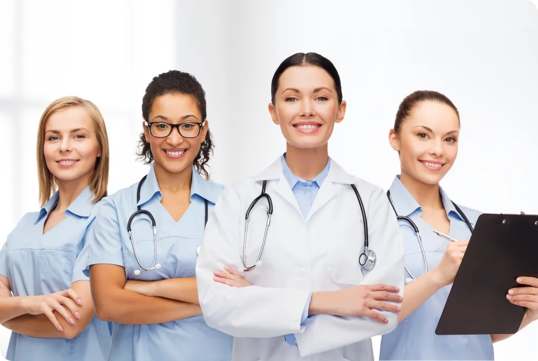 Healthcare team of four women in clinical uniforms and white coat