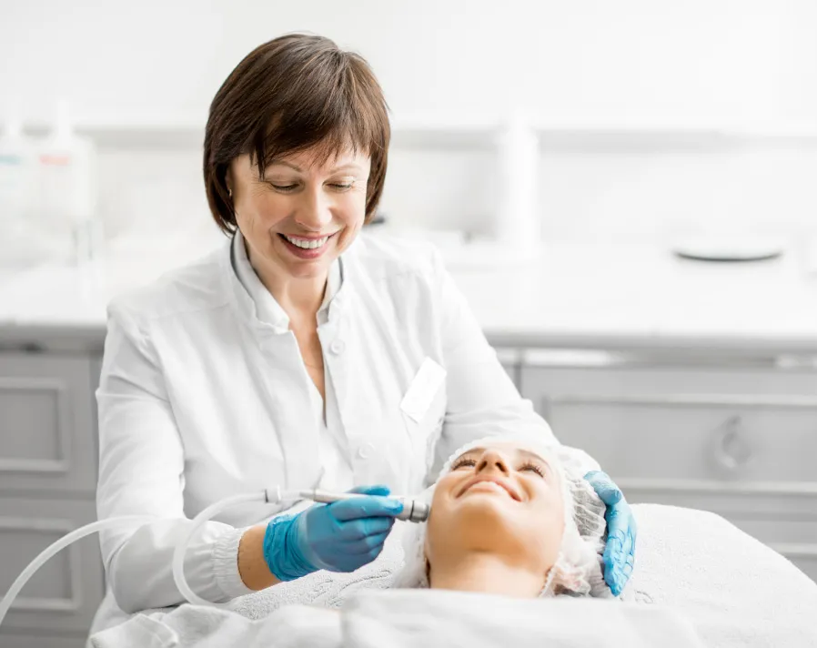 Dermatologist performing a microdermabrasion treatment for skin exfoliation and rejuvenation at a clinic.