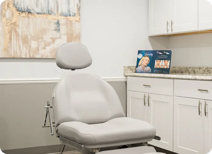 Modern dermatology clinic treatment room with comfortable chair for skin care consultations and cosmetic procedures.
