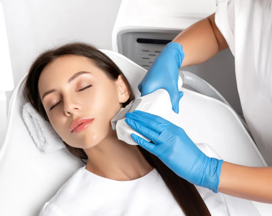 Woman receiving BBL therapy on face and neck from professional in clinical spa setting