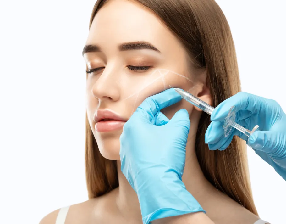 Young woman receiving dermal filler in cheek from professional in clinical setting