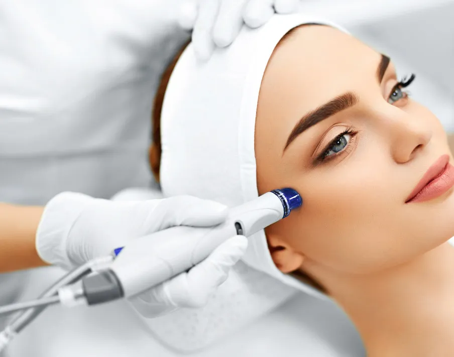 Professional performing MicroLaserPeel on woman's face in clean clinical spa setting