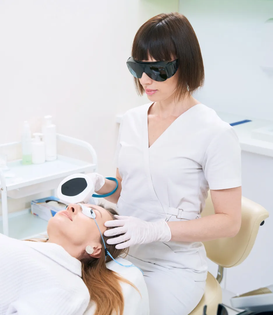 Professional performing laser facial treatment on client in clinical skincare setting