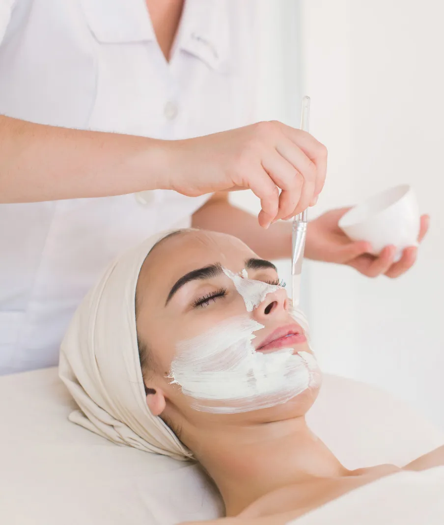 Woman receiving professional chemical peel facial with serum dropper 