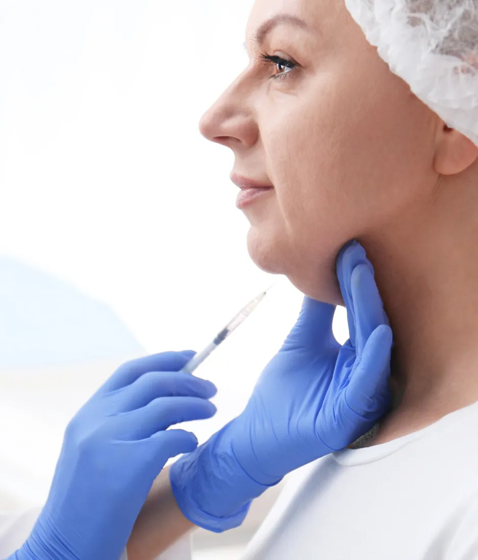 Woman receiving cosmetic injection in chin and jawline from professional in clinical setting